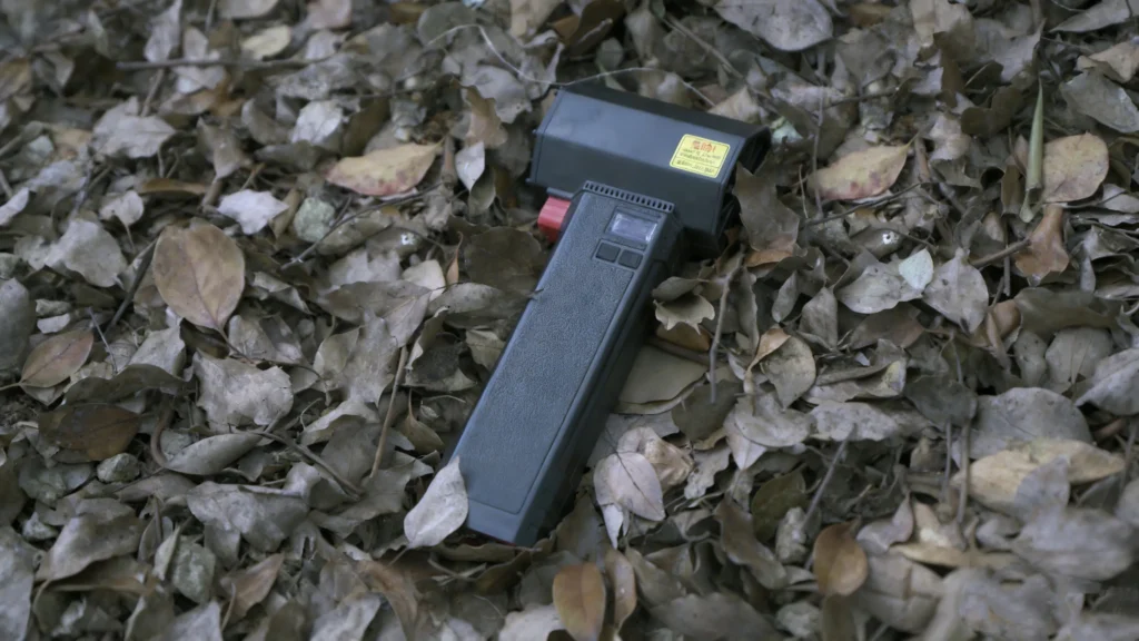 The Booster TF64 air blower is on the ground with leaves.