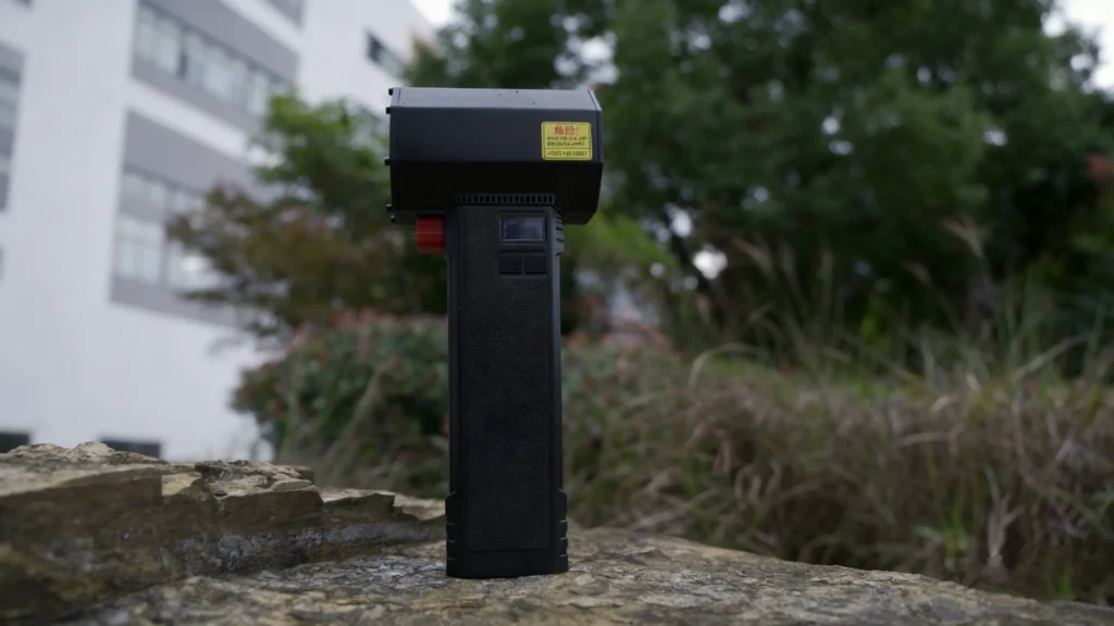 A full-body shot of the Booster TF64 air blower is placed on a rock.