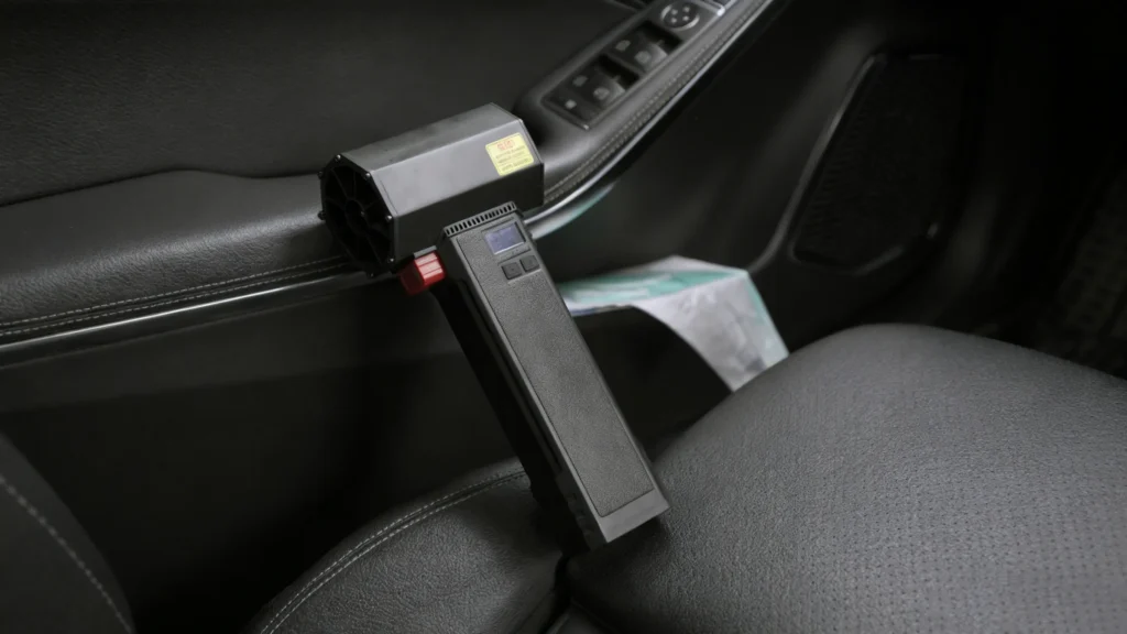 “The Booster TF64 air blower is placed at an angle on the driver’s seat of the car.