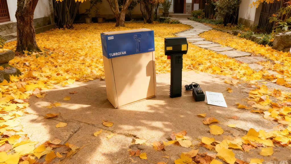 Booster TF64 air blower placed on the ground in a yard with fallen leaves